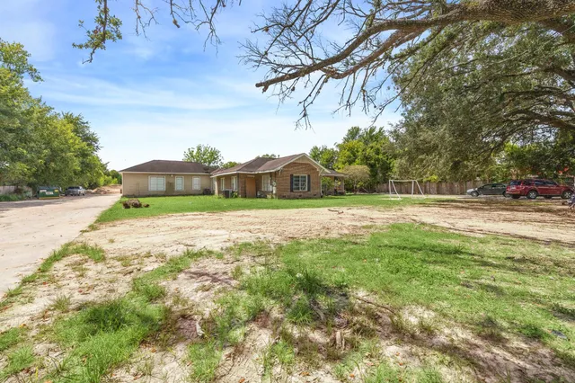 a yellow house with trees in the background