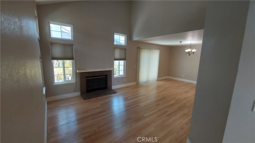 13582 Sweetshade Way Tustin, CA 92782 - Photo 4 of 12 an empty room with wooden floor and fireplace