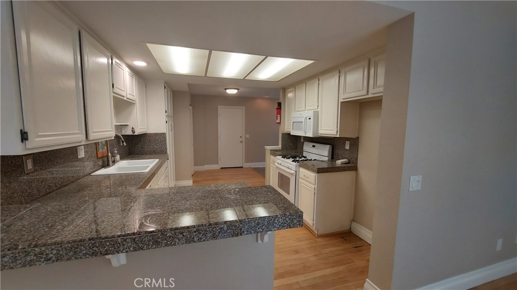 13582 Sweetshade Way Tustin, CA 92782 - Photo 5 of 12 a kitchen with stainless steel appliances granite countertop a sink a stove and a refrigerator