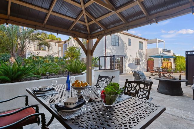a view of a patio with a table and chairs under an umbrella