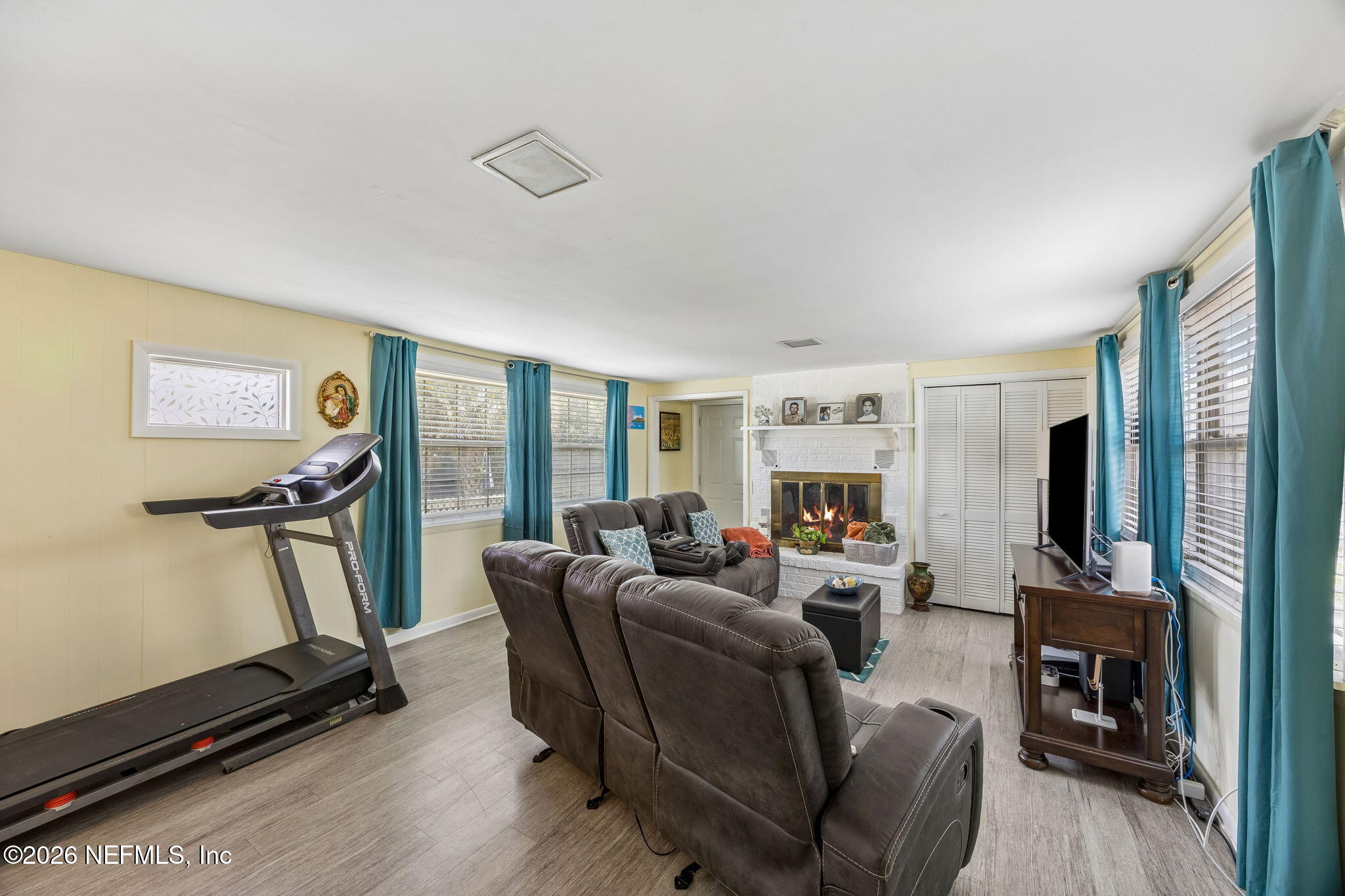 7022 Gaillardia Road South Jacksonville, FL 32211 - Photo 11 of 32 a living room with furniture gym equipment and a flat screen tv