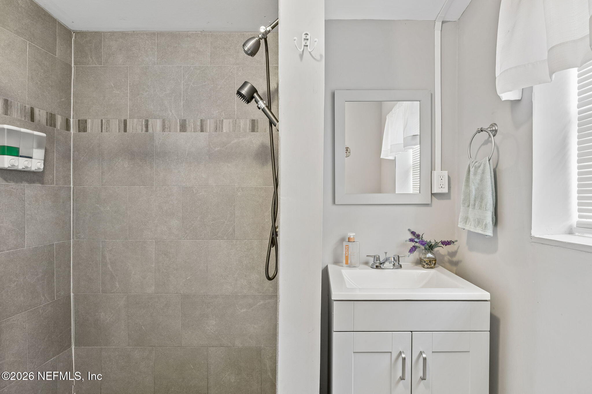 7022 Gaillardia Road South Jacksonville, FL 32211 - Photo 26 of 32 a bathroom with a sink a vanity and shower