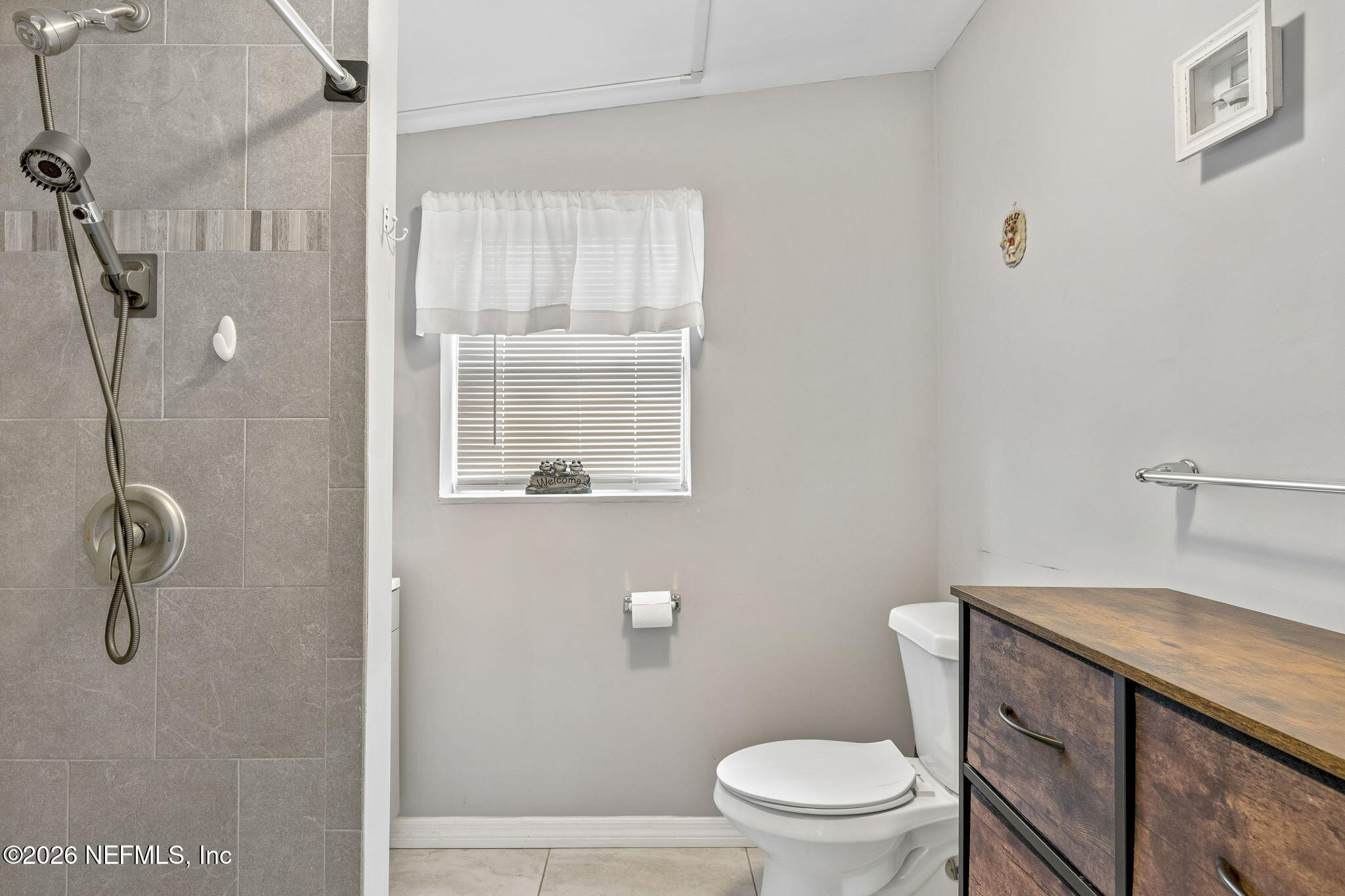 7022 Gaillardia Road South Jacksonville, FL 32211 - Photo 27 of 32 a bathroom with a granite countertop toilet a sink a shower and a window