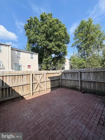a view of backyard with wooden fence and trees