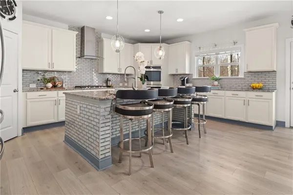 a kitchen with stainless steel appliances kitchen island granite countertop a dining table chairs and sink