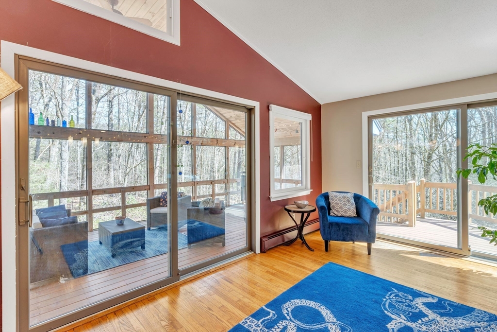 213 North Valley Road Pelham, MA 01002 - Photo 8 of 42 a living room with furniture and a floor to ceiling window next to a dining room