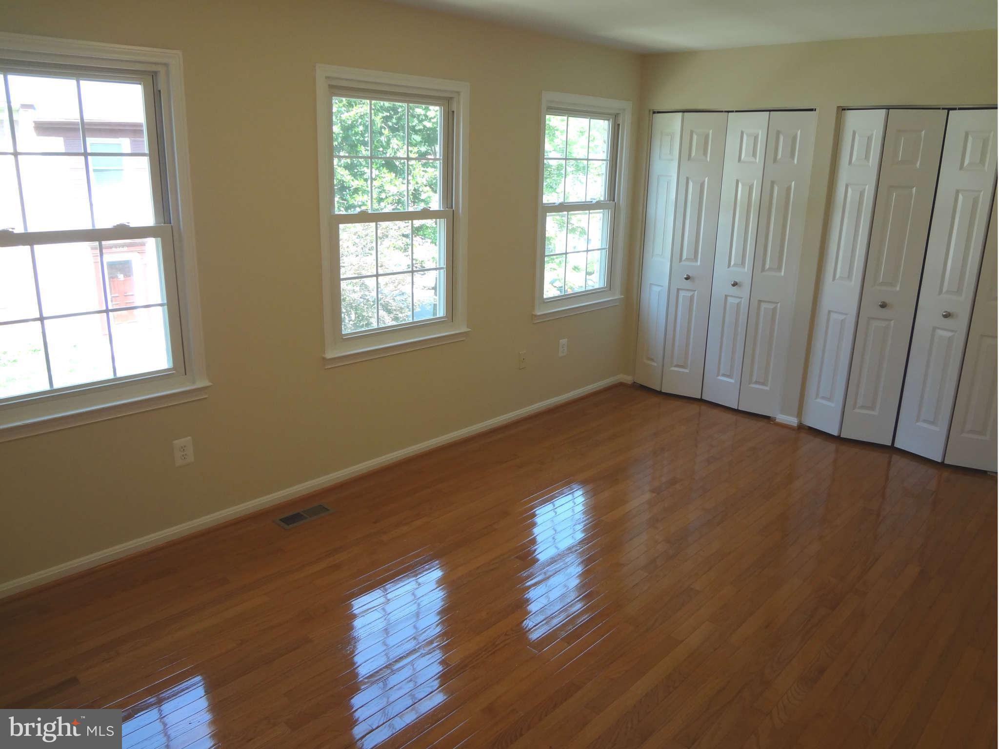 6354 Draco Street Burke, VA 22015 - Photo 13 of 21 a view of an empty room with wooden floor and a window