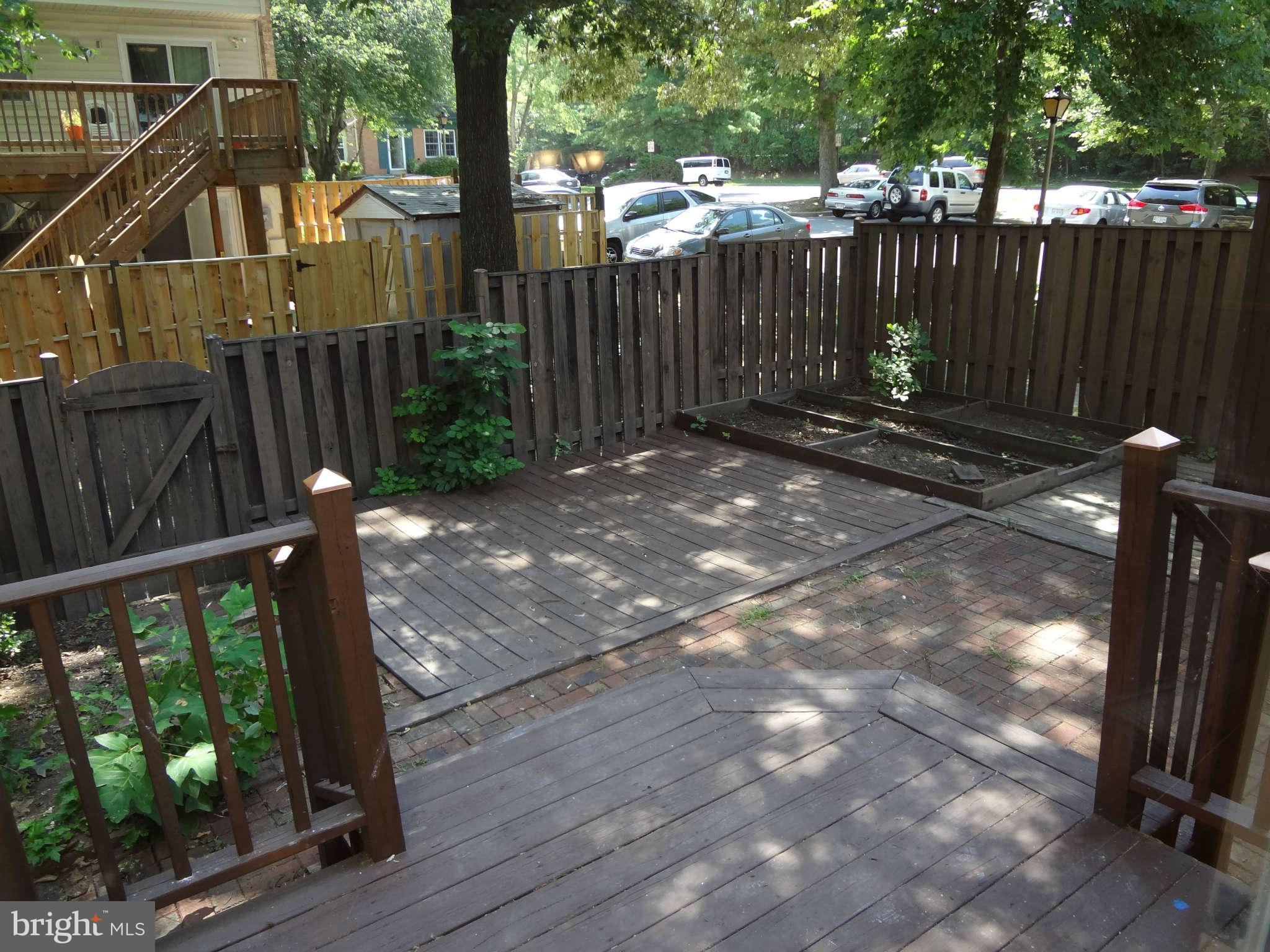 6354 Draco Street Burke, VA 22015 - Photo 18 of 21 a view of a backyard with wooden fence and trees