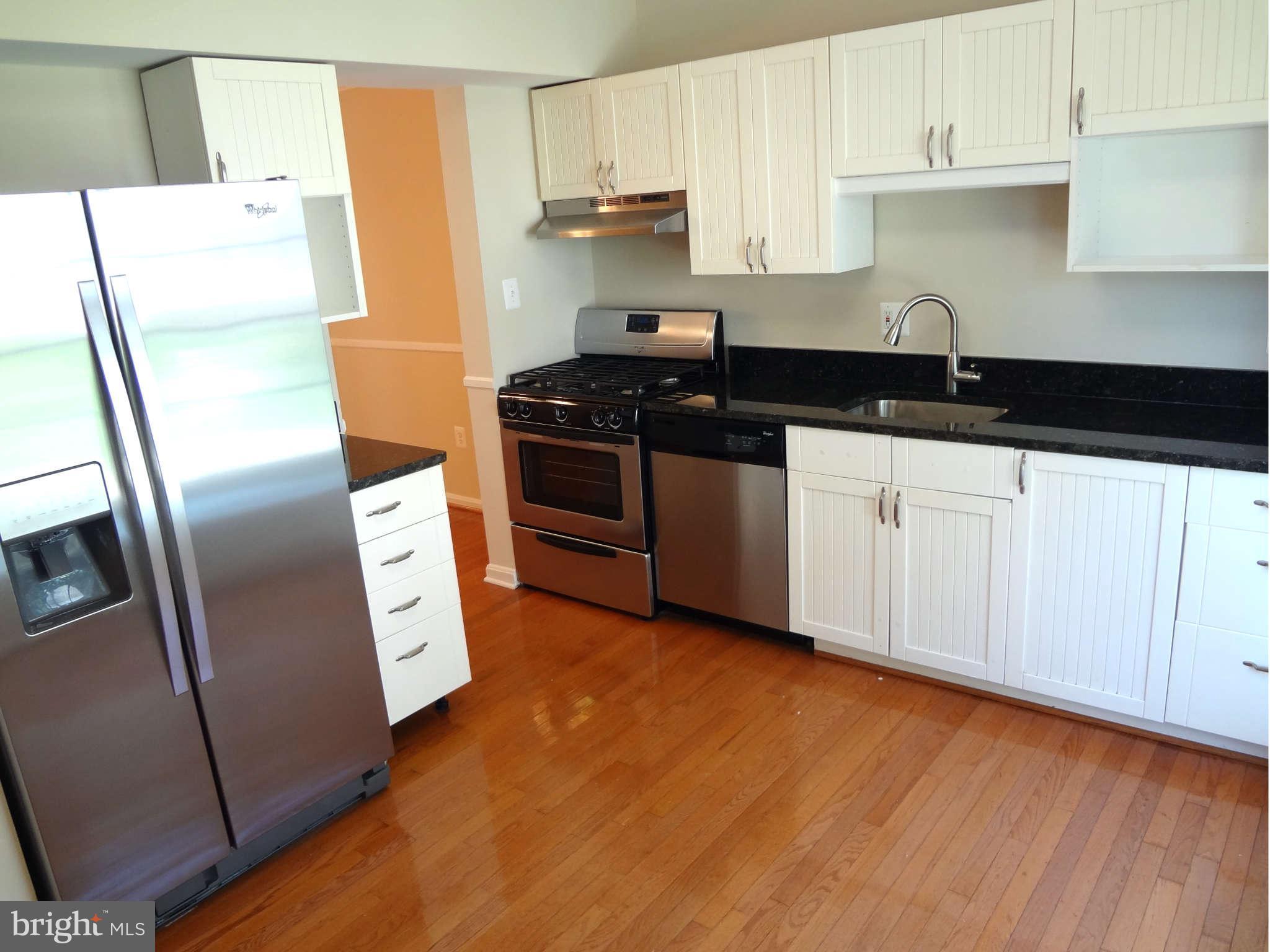 6354 Draco Street Burke, VA 22015 - Photo 6 of 21 a kitchen with stainless steel appliances a refrigerator a sink a stove a microwave and cabinets