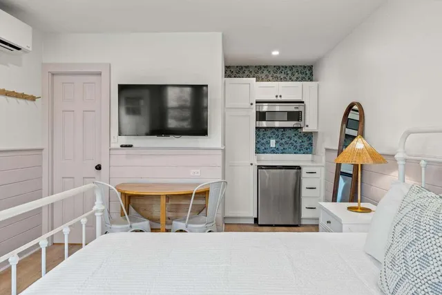a bedroom with a bed and flat screen tv