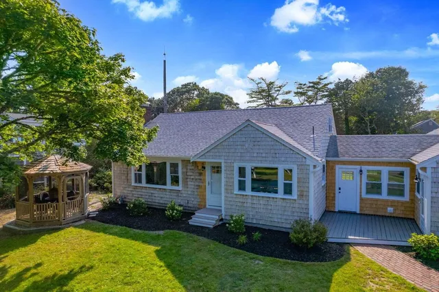 a view of a house with a small yard and wooden fence