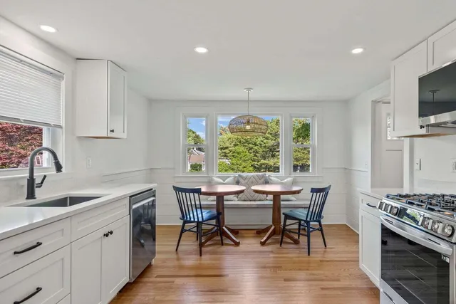a kitchen with sink refrigerator dining table and chairs