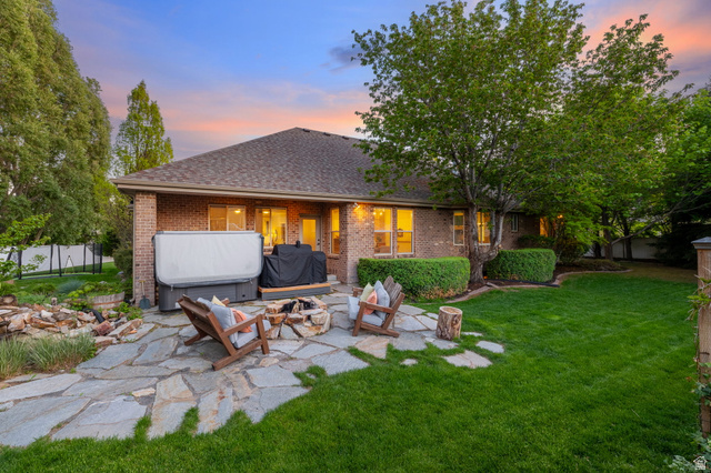 6208 West Bull River Road Highland, UT 84003 - Photo 68 of 90 Spacious backyard featuring a substantial flagstone patio, mature trees, and manicured lawn