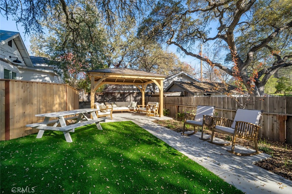 135 18th Street Paso Robles, CA 93446 - Photo 27 of 45 a view of a backyard with table and chairs and a large tree