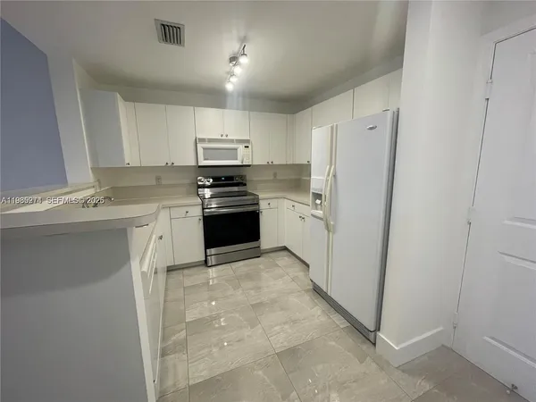 a kitchen with stainless steel appliances granite countertop a stove a refrigerator and a sink