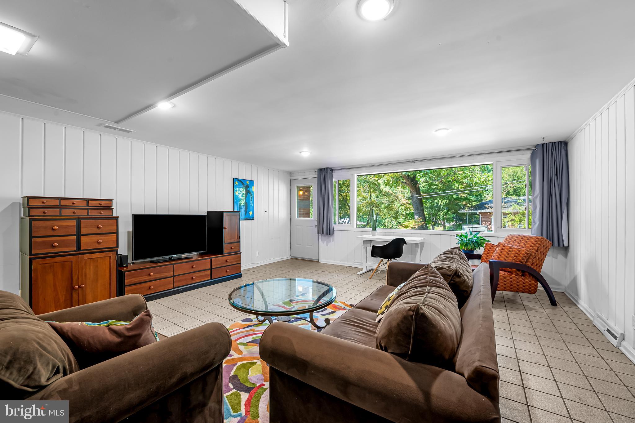 6103 Ivydene Terrace Baltimore, MD 21209 - Photo 36 of 51 a living room with furniture a large window and a flat screen tv