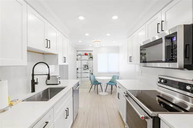 a kitchen with stainless steel appliances a stove a sink a microwave and cabinets