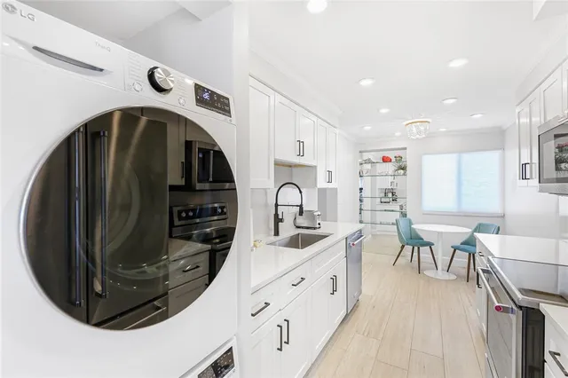 a kitchen with stainless steel appliances a sink a stove and white cabinets
