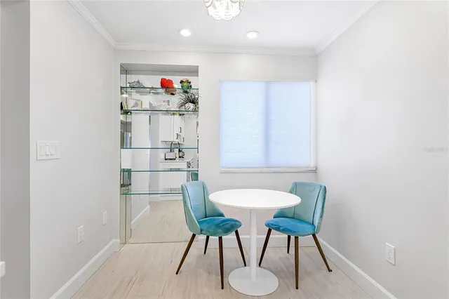 a kitchen with a dining table chairs and a refrigerator