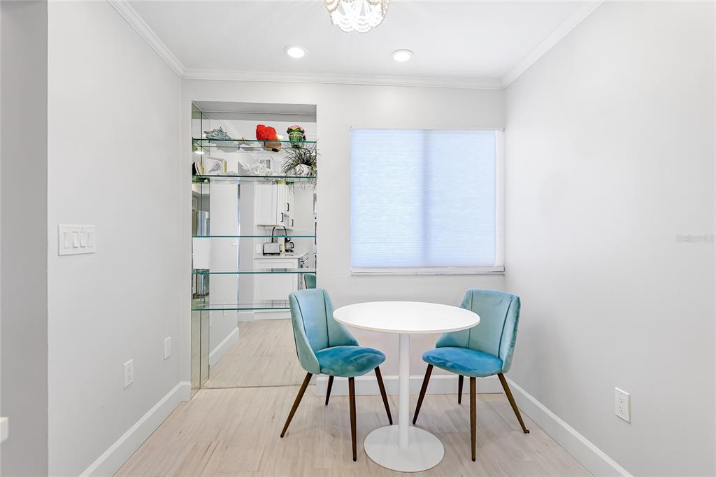 625 Beach Road, Unit 407 Sarasota, FL 34242 - Photo 14 of 43 a kitchen with a dining table chairs and a refrigerator
