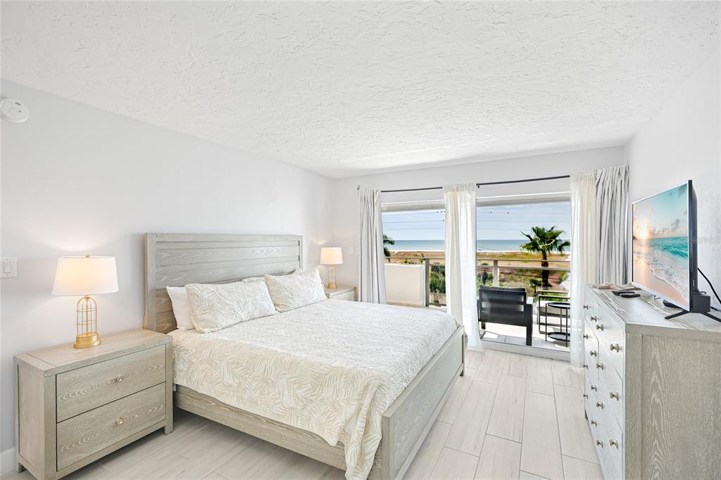 625 Beach Road, Unit 407 Sarasota, FL 34242 - Photo 16 of 43 a bedroom with a large bed and a flat tv screen on dresser