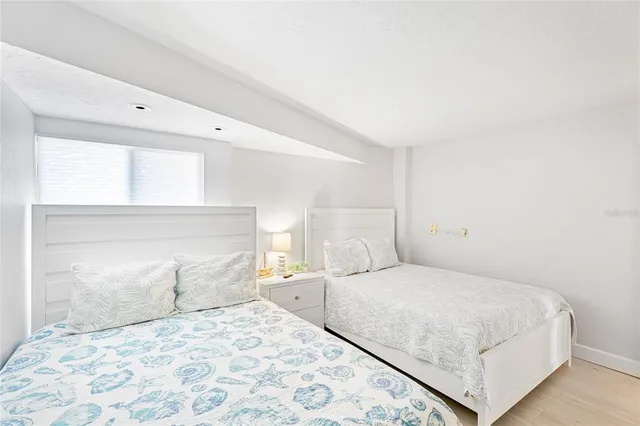 a bedroom with a large bed and a potted plant