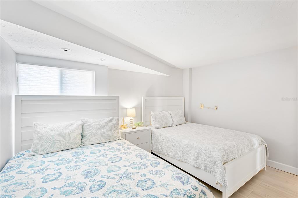 625 Beach Road, Unit 407 Sarasota, FL 34242 - Photo 20 of 43 a bedroom with a large bed and a potted plant