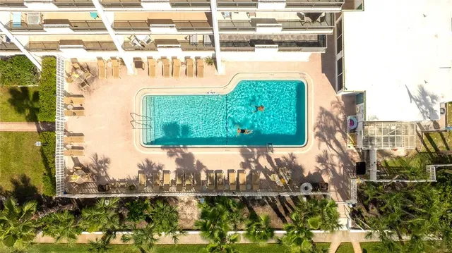 a front view of a house with swimming pool and sitting area