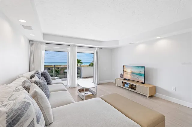 a living room with furniture a flat screen tv and a large window