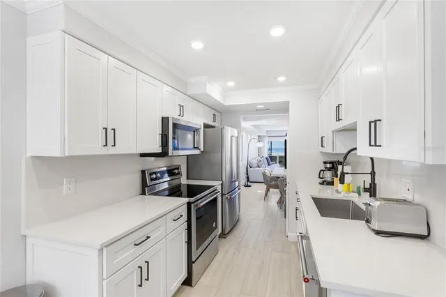 a kitchen that has a lot of cabinets and wooden floor