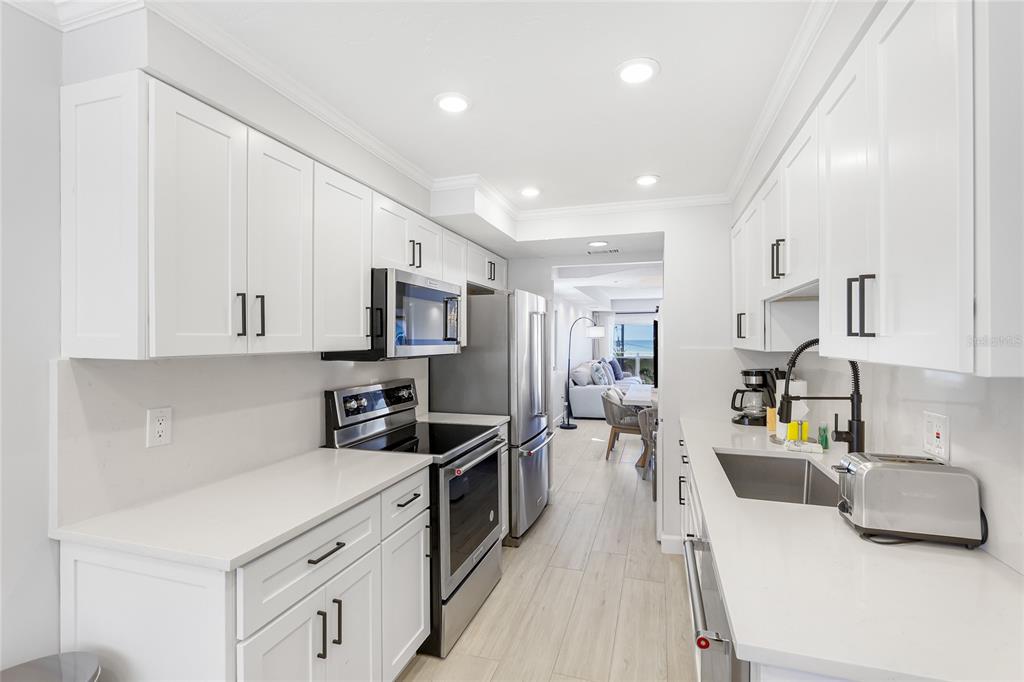 625 Beach Road, Unit 407 Sarasota, FL 34242 - Photo 10 of 43 a kitchen that has a lot of cabinets and wooden floor