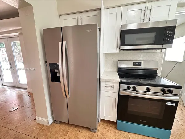 a view of kitchen with stainless steel appliances and refrigerator