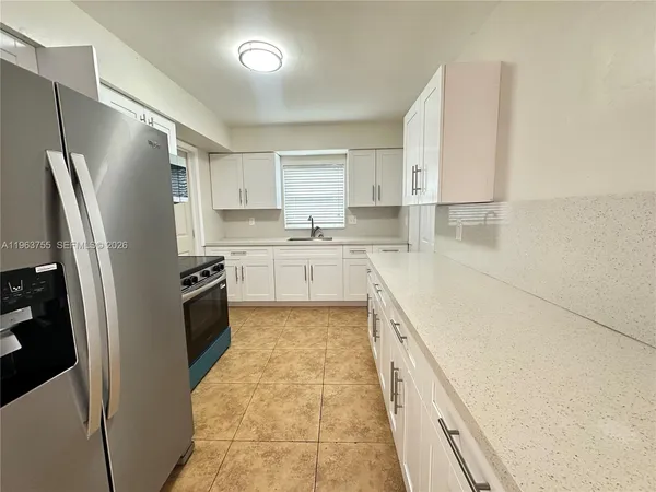 a kitchen with stainless steel appliances granite countertop a refrigerator sink and stove