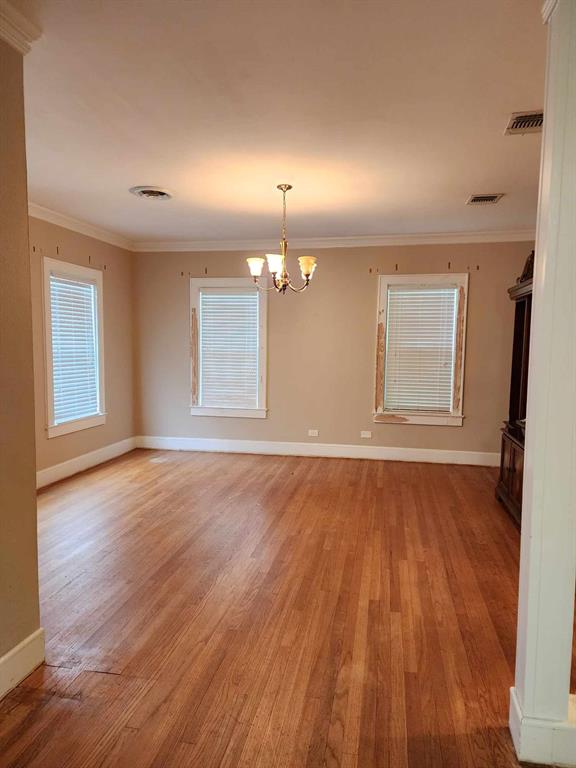 202 Pine Street Logansport, LA 71049 - Photo 11 of 19 Unfurnished room with light hardwood / wood-style floors, an inviting chandelier, and crown molding