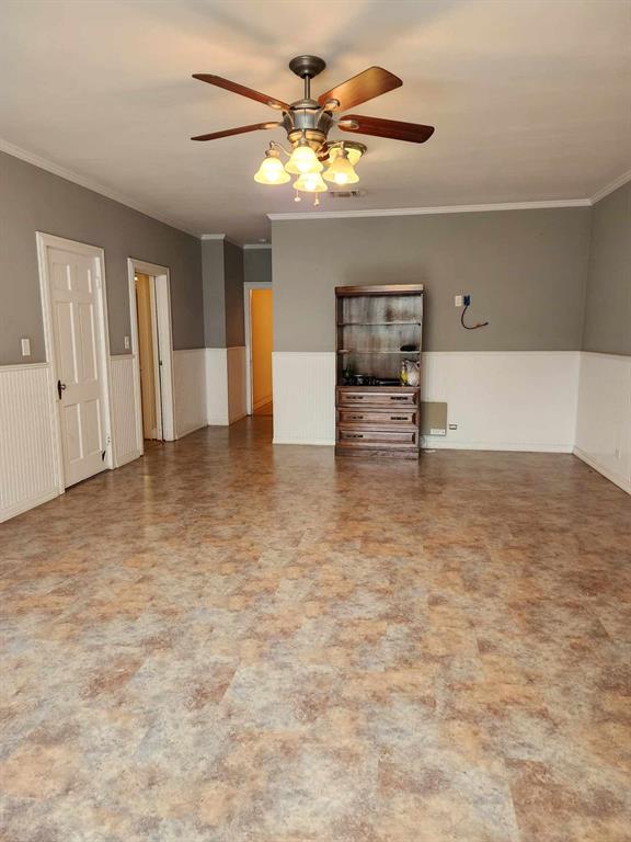 202 Pine Street Logansport, LA 71049 - Photo 12 of 19 Unfurnished living room with ornamental molding, ceiling fan, and tile patterned flooring