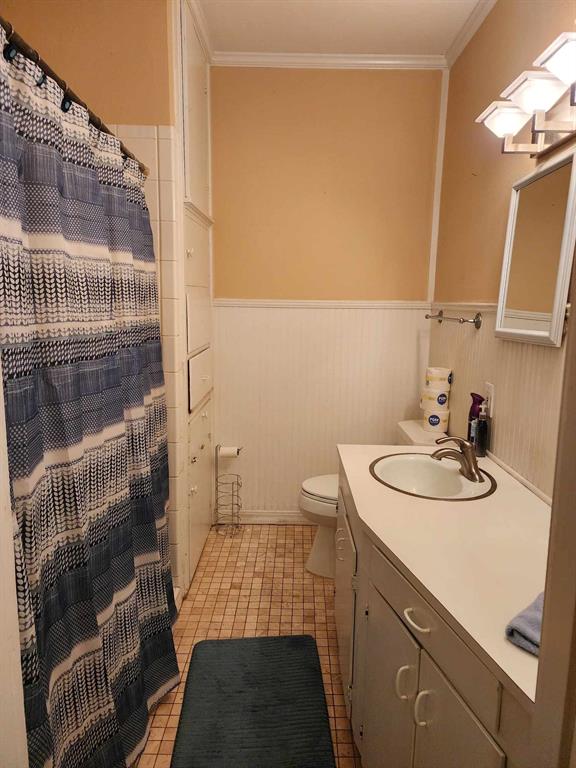 202 Pine Street Logansport, LA 71049 - Photo 15 of 19 Bathroom featuring vanity, crown molding, tile patterned flooring, and toilet