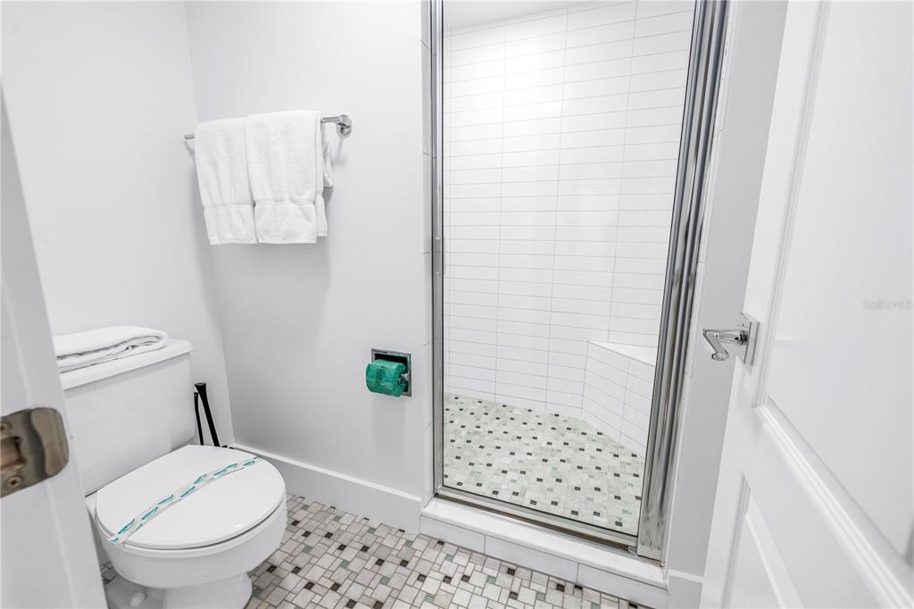 450 Beach Road, Unit 4 Sarasota, FL 34242 - Photo 32 of 64 a white toilet sitting next to a shower curtain