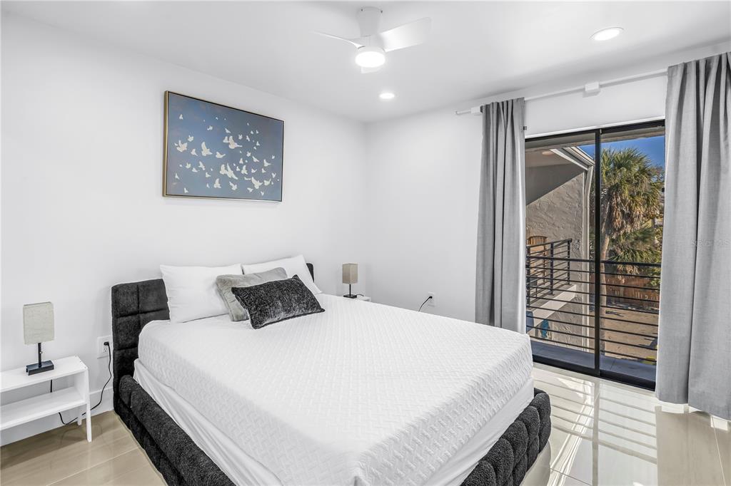 450 Beach Road, Unit 4 Sarasota, FL 34242 - Photo 36 of 64 a bedroom with a large bed and a chandelier