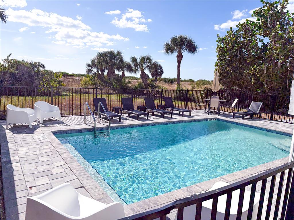 450 Beach Road, Unit 4 Sarasota, FL 34242 - Photo 46 of 64 a view of a swimming pool with a table and chairs