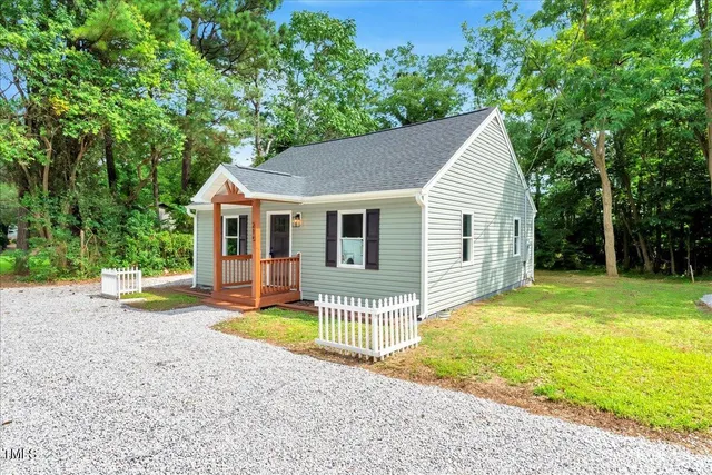 a view of a house with a yard and sitting area