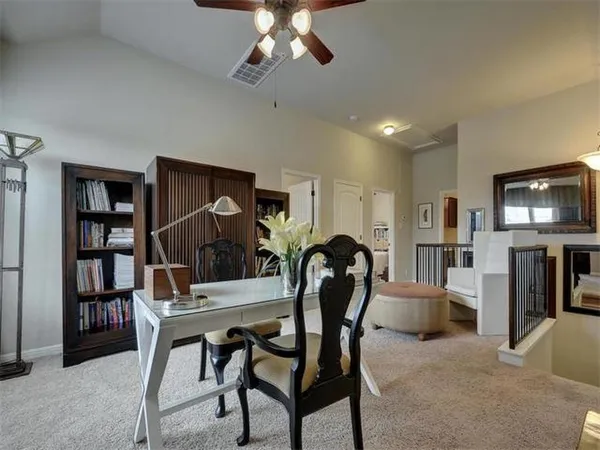 a living room with furniture a bookshelf and a flat screen tv