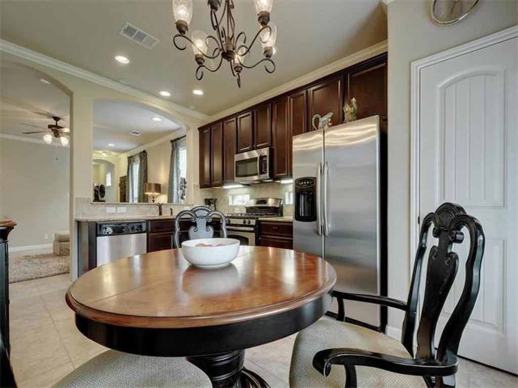14001 Avery Ranch Boulevard, Unit 401 Austin, TX 78717 - Photo 16 of 29 a kitchen with stainless steel appliances granite countertop a refrigerator a stove a sink a dining table and chairs