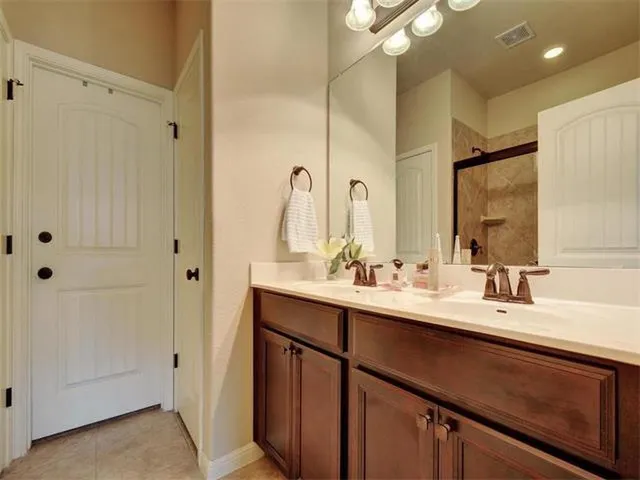 a bathroom with a double vanity sink a mirror and a shower