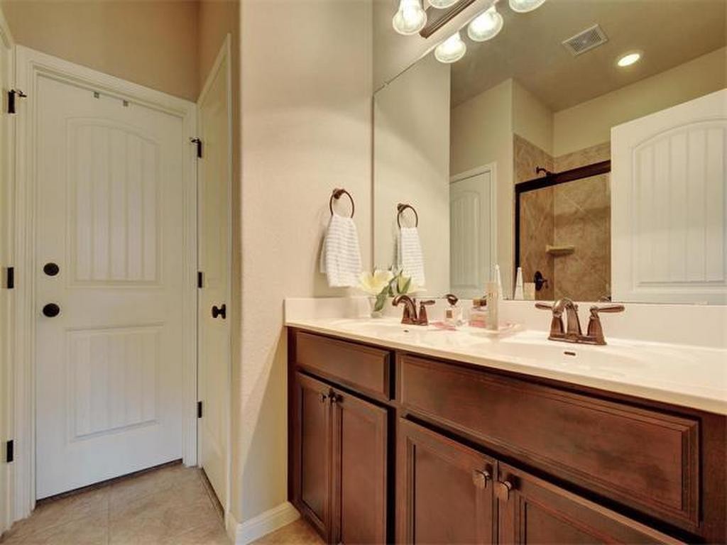 14001 Avery Ranch Boulevard, Unit 401 Austin, TX 78717 - Photo 21 of 29 a bathroom with a double vanity sink a mirror and a shower