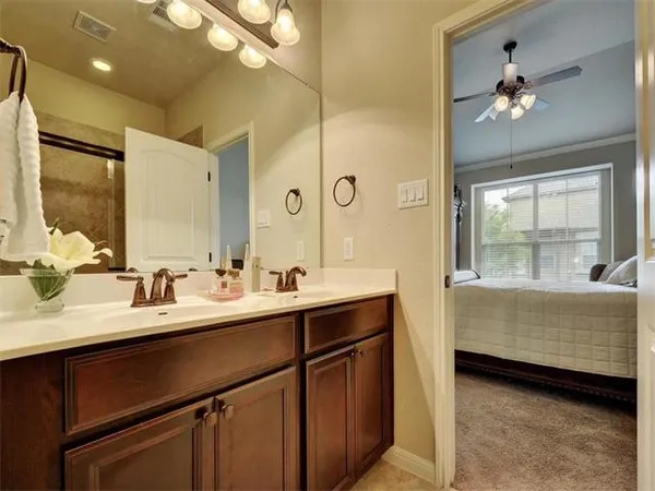 a en suite bathroom with a double vanity sink a mirror and a bathtub