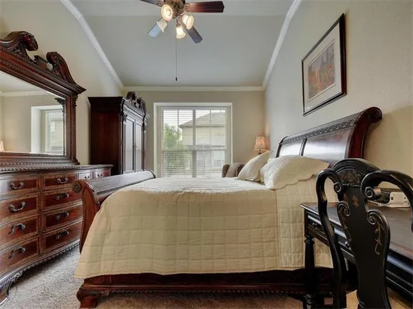 a bedroom with a bed and dresser with mirror