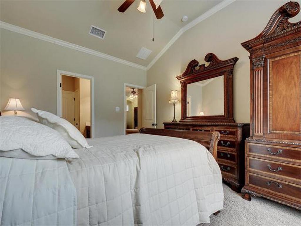 14001 Avery Ranch Boulevard, Unit 401 Austin, TX 78717 - Photo 26 of 29 a bedroom with a bed a flat tv screen and dresser