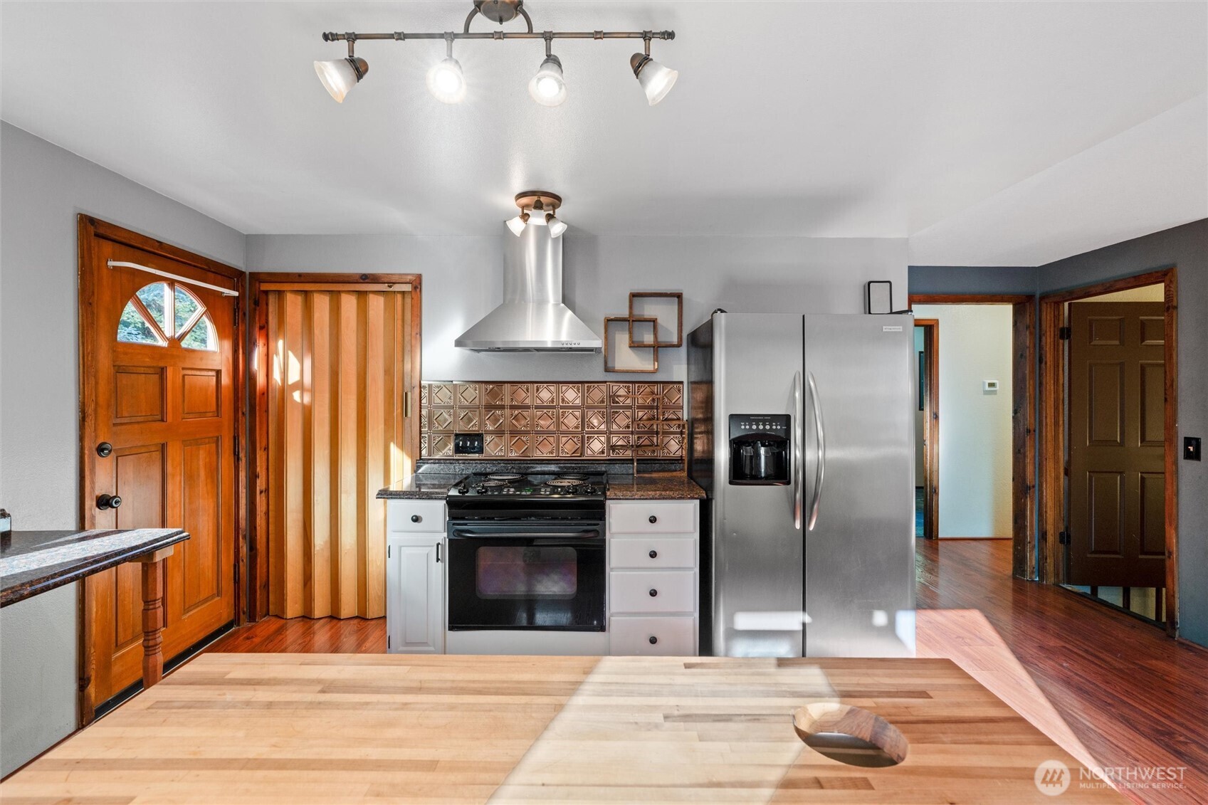 155 Blueberry Hill Road Port Ludlow, WA 98365 - Photo 15 of 39 a kitchen with stainless steel appliances granite countertop a refrigerator a stove and a sink with wooden floors