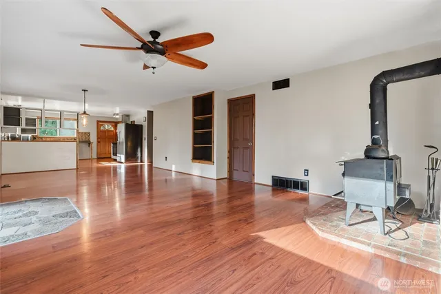 a view of a livingroom with wooden floor and a ceiling fan