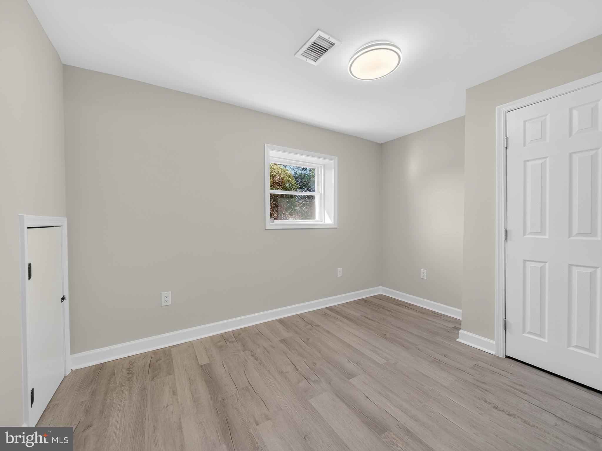 24676 Old 3 Notch Road Hollywood, MD 20636 - Photo 28 of 45 an empty room with wooden floor and windows